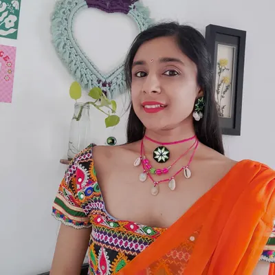 Here's how I styled this layered pink choker set for a Navratri look. It features a mirror work pendant, colorful beads, and cowrie shells, designed to complement a traditional embroidered blouse.