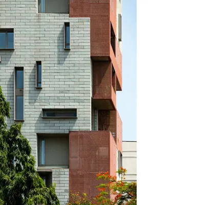 The facade of J-House is a composition of stone and brick, with deep, shaded verandahs. The design is a response to the urban environment, creating a private oasis that engages with the elements thoughtfully.