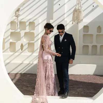 A perfect look for a modern pre-wedding shoot. She is wearing a stunning pale pink embroidered saree, and he is in a sharp, double-breasted navy suit. This is how you coordinate with style.