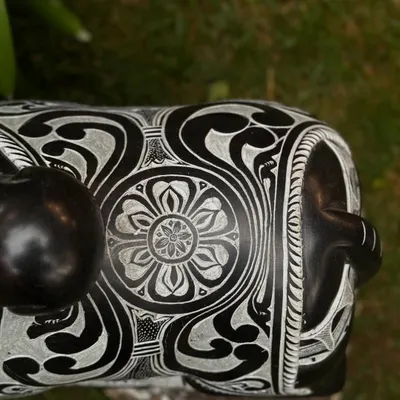 A close-up of a seated Nandi statue, showcasing the intricate floral and geometric patterns carved into the stone by our artisans.