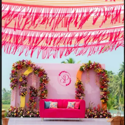 A perfect Haldi stage with a vibrant pink couch, colorful floral arches, and a fringed canopy. This setup at Alila Diwa Goa was all about creating a fun, quirky, and picture-perfect moment.
