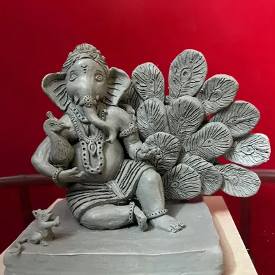 A full view of the 'Mayur Pankh' Ganesha, a custom-designed clay sculpture. Notice the intricate details on the feathers and the small mouse (mushak) at his feet, all handcrafted from natural Shadu clay.