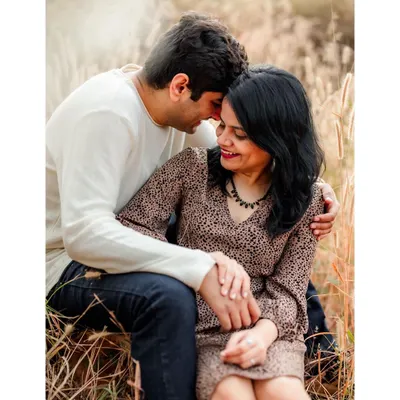 A tender moment shared between a couple, nestled in a field of tall, golden grass. Outdoor sessions like this allow for beautifully natural and romantic portraits.