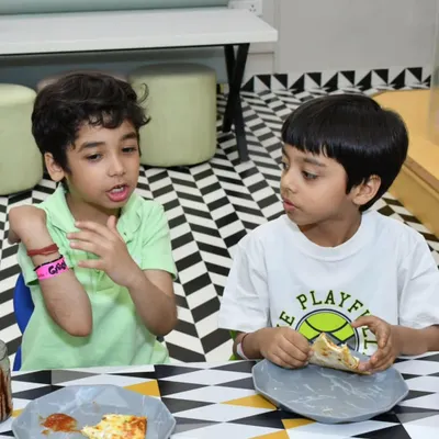 Every bite is a celebration! Our little foodies are in action, enjoying some pizza and chatting during a party. We make sure our cafe is a happy and delicious part of the experience.