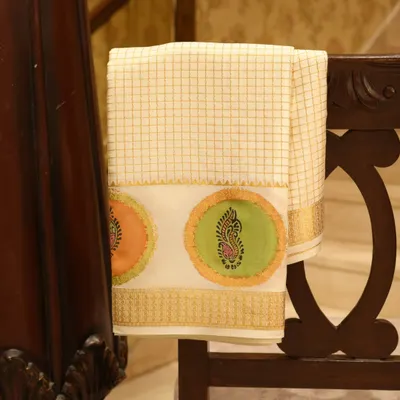 A royal cream and gold Mysore silk saree, distinguished by its shimmering gold zari checks and exquisite hand-block artistry. Mysore silk is celebrated for its softness and subtle sheen.