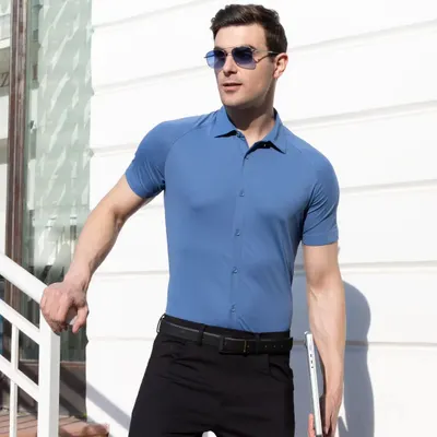 A male model wearing a steel blue Harfunlife shirt, shot outdoors in bright sunlight. The image highlights the shirt's fit and color, while the modern setting gives it a professional and stylish context.