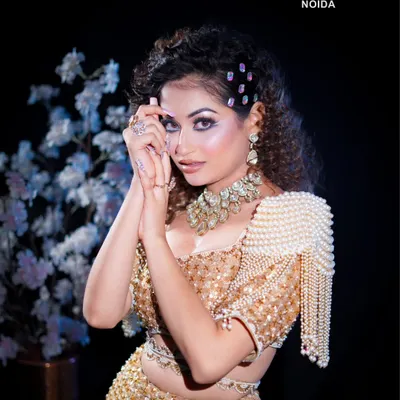 A stunning glam makeup look perfect for any party. This shot highlights the sharp winged eyeliner, shimmering eyeshadow, and intricate pearl-and-gold outfit, a complete look our students learn to create.