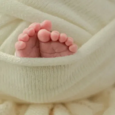 The tiniest details hold the biggest love. A close-up of your newborn's perfect little feet, nestled in a soft wrap, is a simple yet profound reminder of how small they once were. These detail shots are a cherished part of every newborn session.