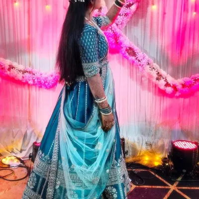 A happy client at her event, looking beautiful in a teal blue lehenga with silver embroidery. It's wonderful to see my outfits be a part of such special moments.