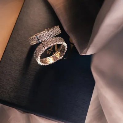A luxurious shot of the couple's diamond-studded wedding bands, symbolizing their promise to reign together in love.