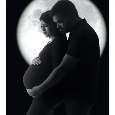 A classic black and white silhouette of a couple against a full moon, their forms creating a beautiful and timeless image of love and anticipation.