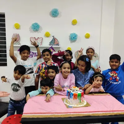 Pure party joy! A happy group gathers for the birthday cake moment after creating their own personalized desk calendars.