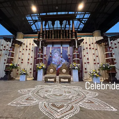 A full view of a traditional baby shower stage. We used majestic pillars, a large Krishna backdrop, and a hand-painted rangoli on the floor to create an authentic and divine atmosphere.