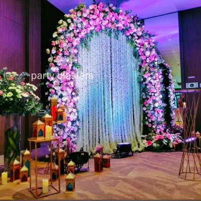 This grand floral arch serves as a stunning focal point. The mix of pink and white roses with a delicate jasmine curtain creates a luxurious and romantic atmosphere perfect for a reception entrance.
