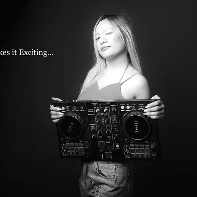A moody black and white portrait of a DJ. The text overlay "Music makes it Exciting..." adds a graphic element, making this a cool, artistic shot for her profile.