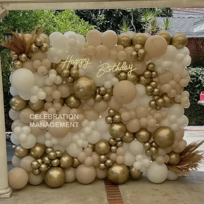 This full-wall balloon installation creates an incredible textured backdrop for photos. I used a mix of nude, white, and chrome gold balloons in various sizes and added a 'Happy Birthday' neon sign for a modern, chic look.