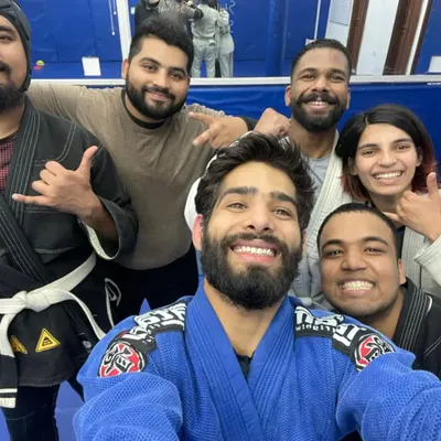 The smiles after a tough roll say it all. This is our BJJ Familia, a diverse group united by a passion for learning and self-improvement.