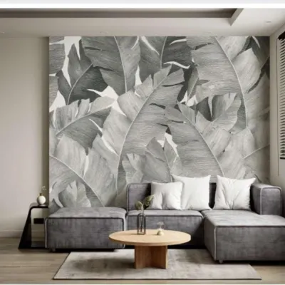 A modern living room featuring a black and white banana leaf wallpaper. This monochromatic design is a stylish and sophisticated way to incorporate a botanical theme.