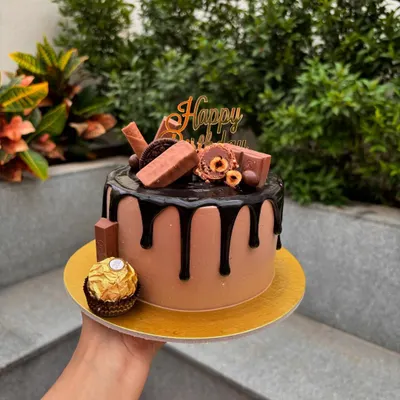 A chocolate lover's dream. This chocolate drip cake is overloaded with treats like Ferrero Rocher, KitKat, and Oreo cookies.