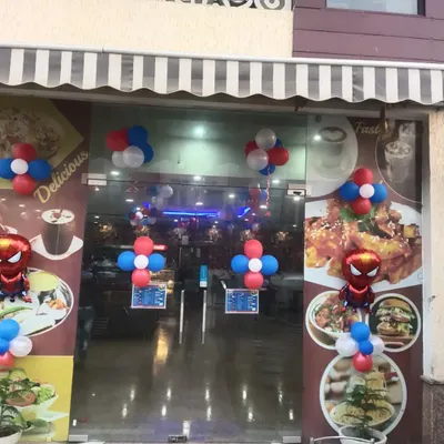 The entrance to this restaurant is decorated with red, white, and blue balloon clusters and a Spiderman foil balloon to welcome guests to a themed party.