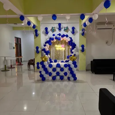 A classic blue and white balloon decoration for a cake table, featuring a half-arch and star foil balloons.