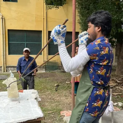 A Raku workshop in action at a school in Dehradun. Here, a student is carefully removing a glowing hot piece from the kiln with tongs, ready for the next stage of the process.