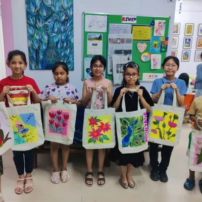 A group of proud young artists showing off their custom-painted tote bags. Our DIY workshops let kids create functional art they can use and be proud of.
