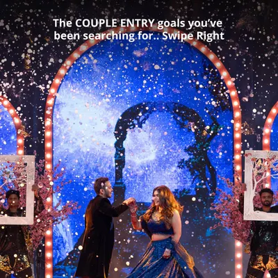 A couple's Sangeet entry that feels like a scene from a movie. The starry night backdrop and performers with framed portraits create a magical and personalized welcome.