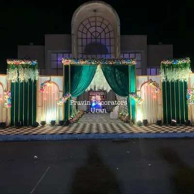 A truly grand entrance I created for an evening event. The structure features rich green velvet curtains, elegant white drapes, and floral arrangements, all beautifully lit against the night sky.
