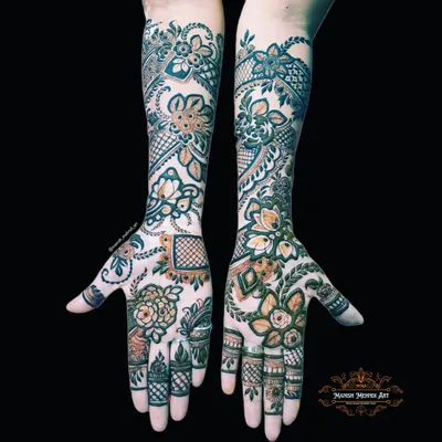 A full bridal mehndi design covering both hands and extending up the arms. The patterns are symmetrical and filled with traditional motifs, creating a rich and classic look for the bride.