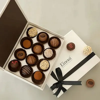 An overhead view of our assorted truffles and pralines gift box. You can see the variety of finishes, from cocoa-dusted to nut-coated and chocolate-drizzled, each promising a unique bite.