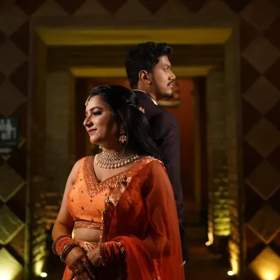 A romantic Sangeet look for the couple. The bride's orange lehenga is complemented by a soft, glowing makeup look.