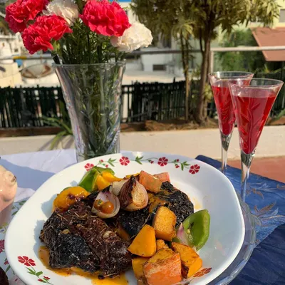 A festive plate of our Roast Xmas Pork Rack, served with roasted vegetables. This dish is perfect for holiday gatherings and showcases a beautifully cooked piece of pork with a rich, flavorful crust.