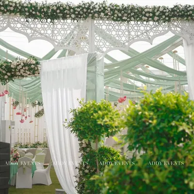 A grand and graceful entrance for a Nikah ceremony. This design for Khan Sir's wedding features a Mughal-inspired arch, pastel green drapes, and pristine white florals, creating a sophisticated and welcoming ambiance.