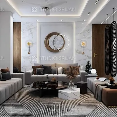 A luxurious drawing room at Rajasthali Apartments, featuring plush sofas, a geometric-patterned rug, and a sculptural screen that elegantly separates the living and dining areas.