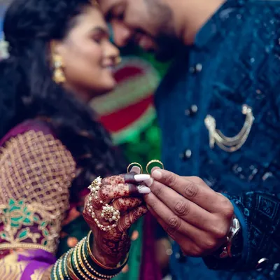 A close-up shot focusing on the couple's hands as they hold their engagement rings, a symbol of their commitment.