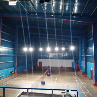 A clear view of our well-maintained, empty badminton courts. This image showcases the professional line markings, high ceilings, and powerful overhead lighting system that ensure optimal playing conditions at any time of day.