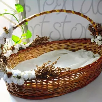 This is an example of a custom-decorated hamper basket, perfect for weddings or special events. The sturdy oval cane basket is adorned with flowers and lined with fabric, ready for gifting.