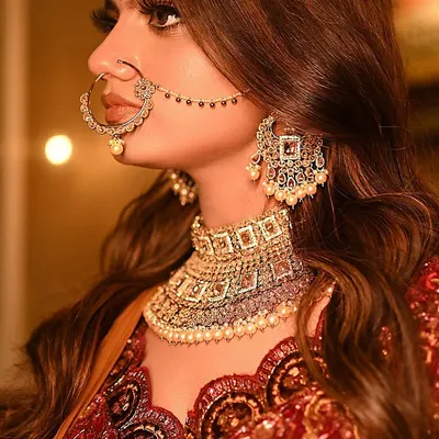 A close-up profile shot that puts the stunning bridal nath, choker, and earrings in full focus. Jewelry shots like this are essential.