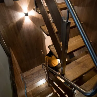 This compact, wood-clad metal staircase was custom-designed to connect two floors within a tight space, demonstrating our ability to create functional and beautiful solutions for any architectural challenge.