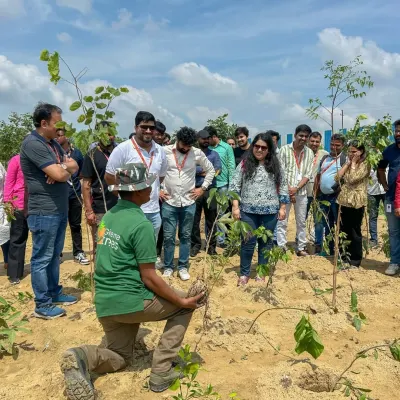 I am demonstrating the correct planting technique to a group of enthusiastic volunteers from EXL. Proper knowledge ensures a higher survival rate for the saplings.