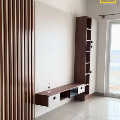 The living room's floating TV unit for Mr. Sharma's home. We combined vertical wooden fluting with clean white surfaces and integrated shelving for a modern and functional entertainment space.