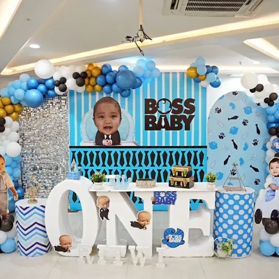 Here is a full view of our Boss Baby theme for Ritwik's first birthday. We included a custom striped backdrop, a large "ONE" table for the cake, character cutouts, and a blue, black, and white balloon arch to create the perfect corporate headquarters for the little boss.