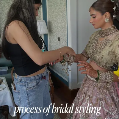 The process of bridal styling is hands-on and detailed. Here, I'm making final adjustments on-site to ensure the bride's pastel lehenga drapes perfectly for her big day.