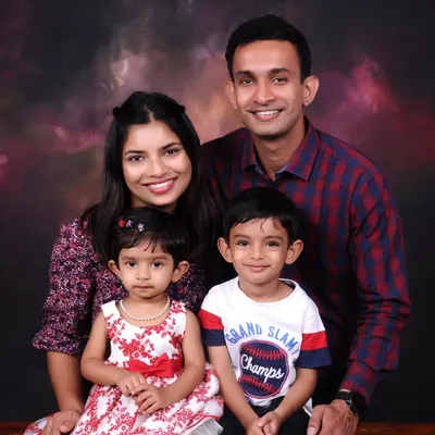 A classic studio family portrait against a warm, painted backdrop. I focus on capturing a relaxed and happy moment with both parents and children looking their best.