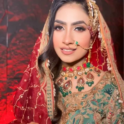 A close-up of a traditional Muslim bridal look. The focus is on soft, glowing makeup and a side-swept hairstyle adorned with a beautiful passa, creating a regal and elegant appearance.