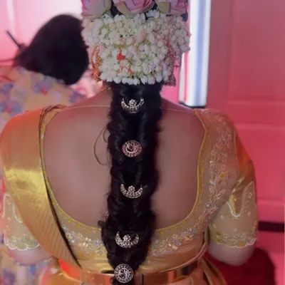 A classic South Indian bridal braid, beautifully decorated with fresh jasmine and lotus flowers, and traditional hair jewelry. This is a timeless style that we teach in our hairstyling module.
