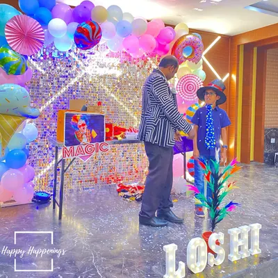 Abracadabra! A magic show is a fantastic way to keep guests of all ages entertained. Here, the magician is getting some help from the birthday boy for a special trick at the Candyland party.