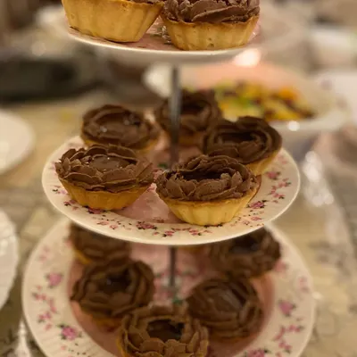 My divine chocolate tarts arranged on a beautiful three-tier stand. They have a crisp shell and a rich chocolate filling, perfect for Iftaar or any high tea.