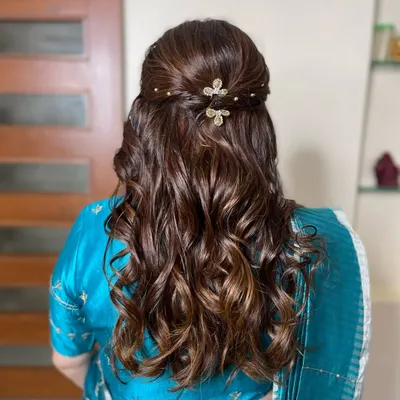 A close-up of the elegant half-up hairstyle for the mom-to-be. The soft curls are gathered with a twist and adorned with delicate, sparkling butterfly clips.